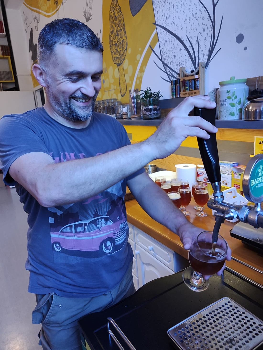 Jugoslav Župić laughing as he pours a Varcar from the tap at Visitor Center Pecka