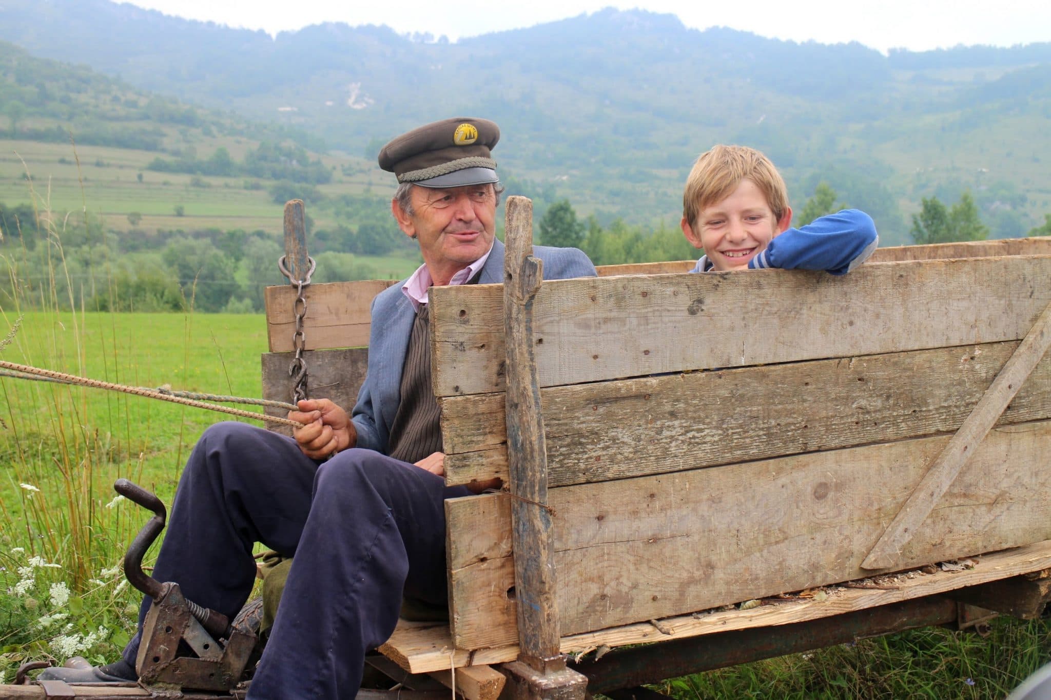 Mještani na drvenim zaprežnim kolima u Peckoj